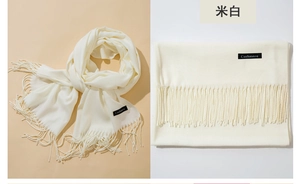 Detail of soft rice white cashmere feel scarf showing texture, tassels and brand label