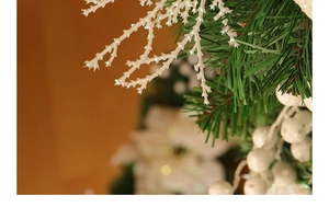Close-up of frosted pine needles with white glitter branches and festive winter berries