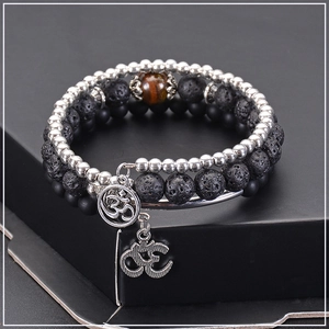 Detail of triple-layer lava stone and tiger eye bead bracelet with Om charm