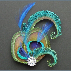 Detail of peacock feather fascinator featuring a central pearl and sparkling diamond accents