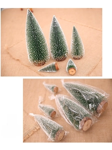 Detailed view of 5 mini Christmas trees with white snow effect and wooden bases in packaging