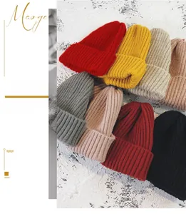 Detail of multi-color thick knit beanies showing ribbed texture and winter warm fabric