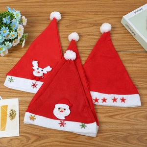 Three festive Christmas hats with reindeer, Santa, and stars on a wooden surface