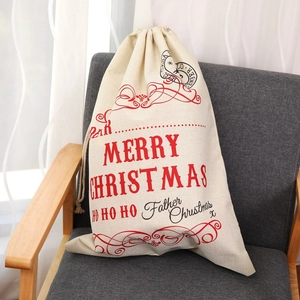 Detail of Christmas burlap gift bag with red printing on rustic canvas material