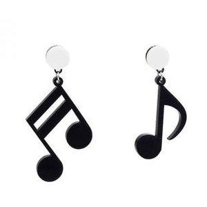 Detail view of asymmetric black musical note earrings with silver posts on white base