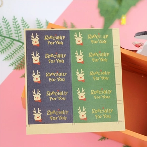 Close-up of reindeer sealing stickers with gold foil on dark green and blue paper