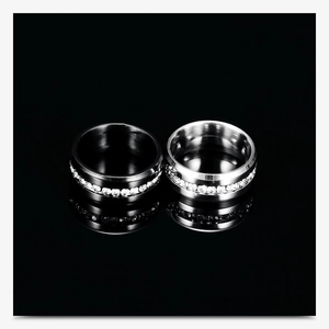 Close-up of black and silver stainless steel rings featuring a full row of set crystals