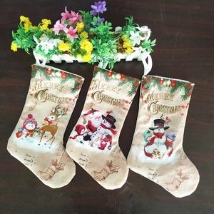 Three vintage Christmas stockings with Santa, Snowman and Reindeer on wood background