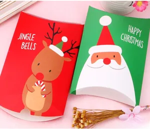Close-up of festive paper pillow boxes with reindeer and Santa designs for holiday treats