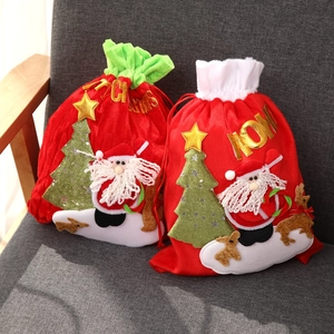 Detail of red velvet Christmas gift bags featuring sequined Santa and reindeer embroidery