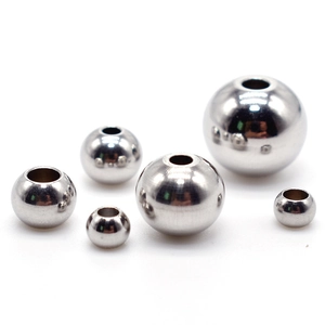 Polished stainless steel round beads with hole in various sizes on white background