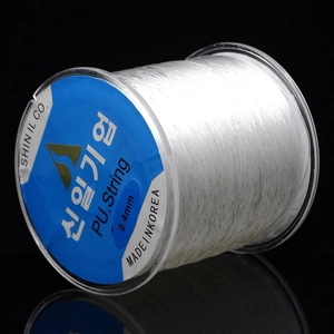Close-up of 0.4mm clear elastic beaded string on a spool for DIY jewelry making