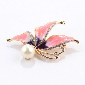 Macro view of butterfly brooch featuring pink enamel wings and sparkling rhinestones