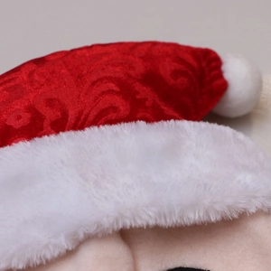 Close-up of red patterned Christmas hat with white plush trim and fuzzy pom-pom texture