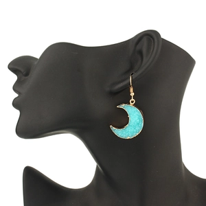 Detail of crescent moon earrings with teal crystal druzy and gold-plated hooks