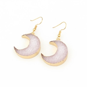 Detailed macro of crescent moon resin earrings with gold edges and purple druzy texture