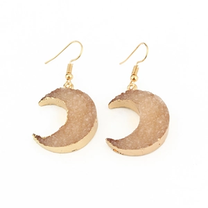 Detail of crescent moon earrings with gold frame and light pink crystal texture