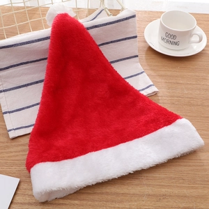 Classic plush red and white Christmas hat displayed on a cozy wooden holiday table