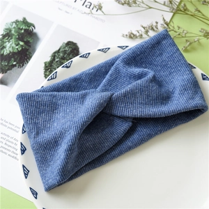 Detail of blue ribbed knit cross-knot headband texture on decorative white tray