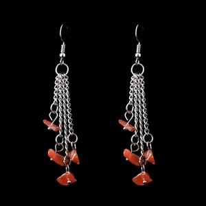Detail of silver-tone tassel earrings with natural orange stone beads on black back