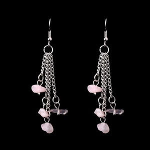 Detail of handmade long tassel earrings with natural pink crystal stones on silver chains