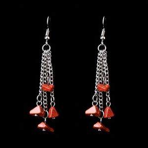 Detail of long silver tassel earrings featuring natural red crystal stone beads