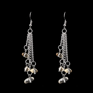 Macro detail of long layered silver chain tassel earrings with natural yellow stone beads