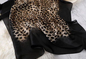 Detailed view of leopard print chiffon scarf with elegant black sheer fabric borders