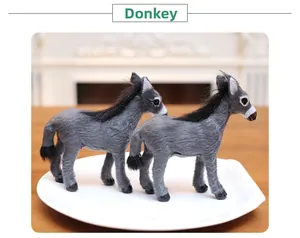 Detail of two realistic grey donkey figurines with artificial fur on white display tray