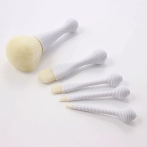 Detail view of 5-piece portable makeup brush set with spiral white handles and beige bristles