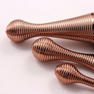 Detailed view of the rose gold metal massager featuring a unique spiral thread design