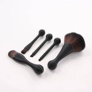 Detailed close-up of 5 makeup brushes with black threaded handles and gradient bristles