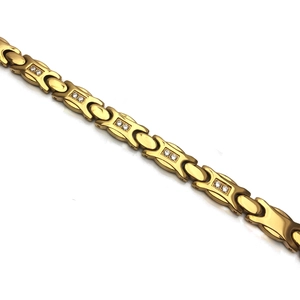 Détail d'un bracelet magnétique en acier inoxydable doré avec zircon et pierre noire