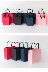 Minimalist paper gift bags in red, black, blue, and pink colors with sturdy black handles