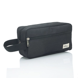Close-up of black canvas toiletry bag with side handle and front zipper pocket detail