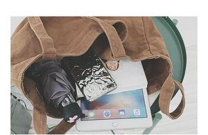 Macro shot of large canvas tote bag interior showing ample space for tablets and umbrellas