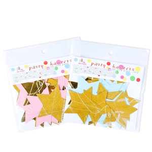Detail of glitter star paper garlands in gold pink and blue for party decorations