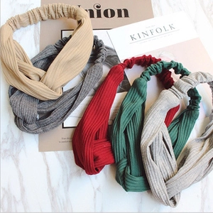 Crossed knit headbands in five colors on marble background with magazine props