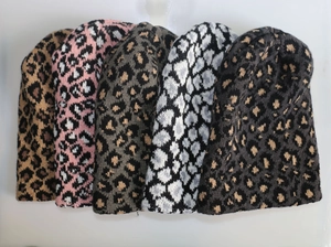 Detailed flat lay of leopard print knitted beanies in five different stylish color options