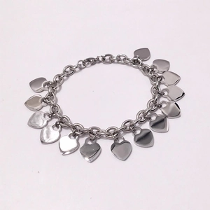 Close-up of heart-shaped pendants on polished stainless steel chain bracelet with clasp