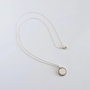 Detailed view of S925 sterling silver necklace featuring a beaded round coin pendant