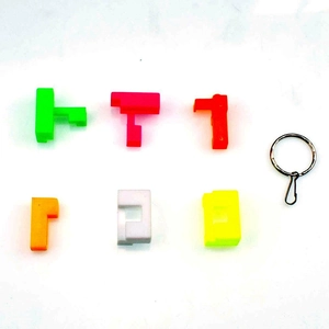 Close-up of 6 colorful Tetris-shaped plastic puzzles with a metal lobster clasp keychain