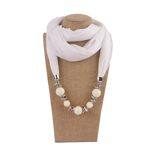 Close-up of white scarf necklace with elegant pearls and silver metallic beads on a bust