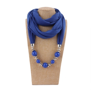 Detail of blue fabric scarf necklace with vibrant large beads and silver accents