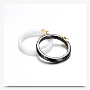Detail of interlocking black and white ceramic rings with gold butterfly accents