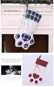 Close-up of paw-shaped Christmas stockings with plaid hearts and bone-shaped tags