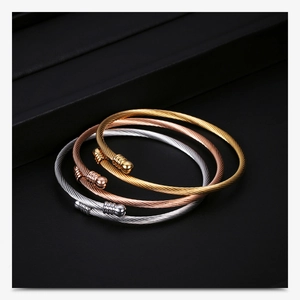 Detailed close-up of three 18K gold-plated cable wire bangles in gold, rose gold and silver