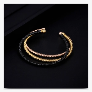 Detailed view of triple-colored cable twist bangles in gold, rose gold and black finish