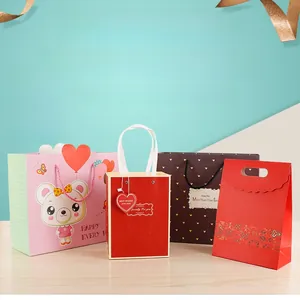 Détail de sacs cadeaux en papier premium avec poignées en ruban et motifs décoratifs