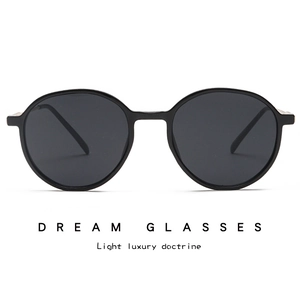 Close-up of retro round black sunglasses with metallic rivet detail and UV lenses